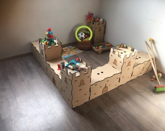 May include: A wooden castle playset for children, made of multiple connected sections, with a tower on each end. The castle is made of natural wood and has a light brown color. The castle is set up on a wooden floor and there are various toys inside the castle, including a toy car, a toy airplane, and a toy castle.