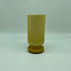 An Opaque yellow glass vase with scalloped top edge