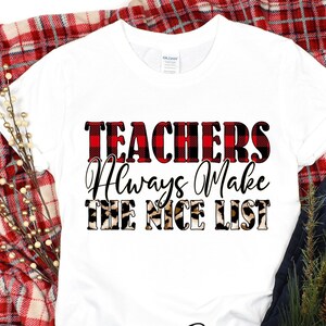 May include: White t-shirt with the text "TEACHERS Always Make THE NICE LIST" in red buffalo plaid and leopard print. The shirt is displayed on a red and white plaid blanket with decorative accents.