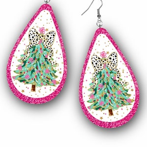 Può includere: Paio di orecchini a goccia con un design a forma di albero di Natale. Gli orecchini presentano un albero verde acqua con ornamenti rosa e un fiocco bianco e nero. I bordi sono delineati con glitter rosa brillante.