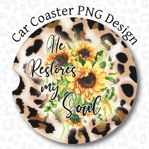 May include: A round car coaster with a leopard print background. The coaster features a watercolor illustration of sunflowers and the text "He Restores My Soul".