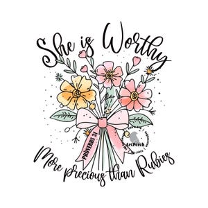 May include: A floral bouquet with pink and yellow flowers, tied with a pink ribbon with the text "Proverbs 31" on it. The text "She is Worthy More precious than Rubies" is written below the bouquet.