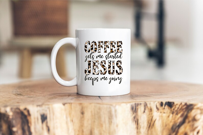 Pode incluir: Caneca de caf&eacute; de cer&acirc;mica branca com um design de estampa de leopardo preto e marrom. O texto "COFFEE gets me started JESUS keeps me going" est&aacute; impresso na caneca.