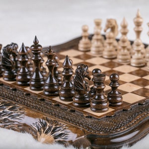 May include: A wooden chess set with dark brown and light wood pieces on a carved wooden board. The board has a dark brown and light wood checkered pattern.