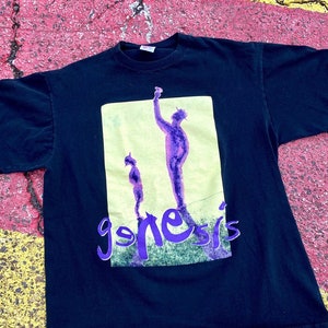 May include: Black t-shirt with a purple and green graphic of two figures and the word "genesis" in purple lettering.