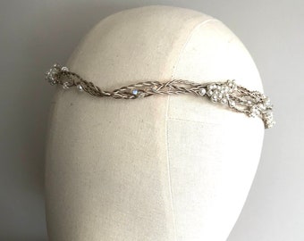 May include: A gold braided headband with pearl and crystal accents. The headband is on a white mannequin head.