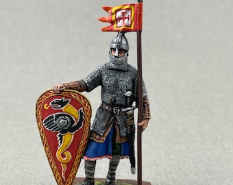 Peut inclure: Figurine miniature de chevalier médiéval, vêtu d'une cotte de mailles et d'un casque, tenant un bouclier avec un motif de dragon et une lance avec un drapeau rouge et jaune. Le chevalier se tient sur un petit socle.