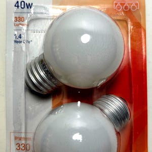 May include: Package of two soft white GE light bulbs. Each bulb is a globe shape with a silver base. The packaging indicates 40W, 330 lumens, and a 1.4-year life.