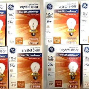 Puede incluir: Múltiples cajas de bombillas GE Crystal Clear. Cada caja presenta un gráfico de bombilla, el texto "crystal clear" e información sobre la eficiencia energética. Las cajas son principalmente blancas, rojas y naranjas.