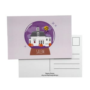 May include: A postcard with a snow globe illustration. Inside the globe is a white house, pumpkins, and bats against a purple night sky. The word "SALEM" is at the base. The postcard is light purple.