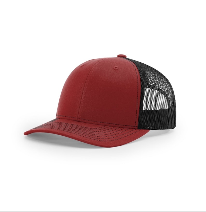 May include: A red and black trucker hat with a mesh back. The hat has a curved brim and a structured crown.