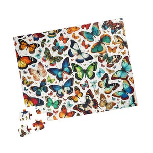 May include: A colorful jigsaw puzzle featuring a pattern of butterflies in various shades of blue, green, orange, red, and yellow. The puzzle is partially assembled, with some pieces missing.