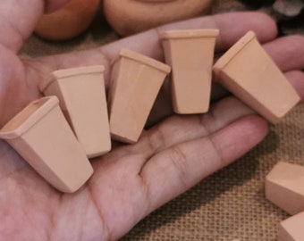Könnte beinhalten: Sechs kleine Blumentöpfe aus Terrakotta in verschiedenen Größen, die auf einer Hand angeordnet sind. Die Töpfe sind unglasiert und haben eine raue Textur.