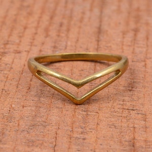 Puede incluir: Un anillo dorado con un diseño en forma de V.