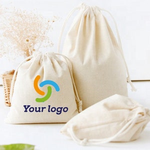 May include: Three natural-colored cotton drawstring bags. One bag has a logo with the text "Your logo" and a colorful design.