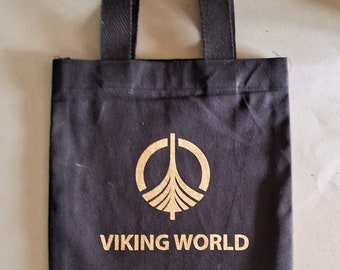May include: A black canvas tote bag with a gold logo and the text "VIKING WORLD".
