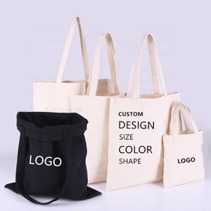 May include: Four tote bags, three are beige canvas with black text that reads "CUSTOM DESIGN SIZE COLOR SHAPE" and "LOGO". The fourth bag is black canvas with white text that reads "LOGO".