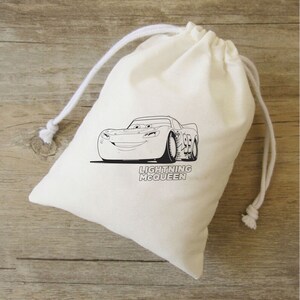 Puede incluir: Una bolsa de algod&oacute;n blanco con cord&oacute;n de ajuste que muestra una ilustraci&oacute;n en blanco y negro de Rayo McQueen de la pel&iacute;cula Cars. La bolsa tiene el texto "Lightning McQueen" impreso.