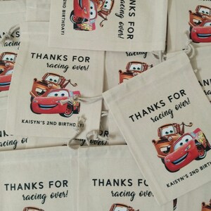 Puede incluir: Bolsas de regalo de fiesta con tem&aacute;tica de Cars, rojas y naranjas, con el texto "&iexcl;Gracias por correr!" y "&iexcl;Kaisyn's 2nd Birthday!" impreso en ellas.