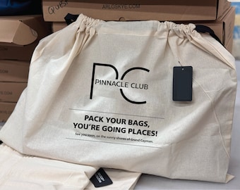 May include: A white drawstring bag with black text that reads "Pinnacle Club" and "Pack your bags, you're going places!"  See you soon, on the sunny shores of Grand Cayman.