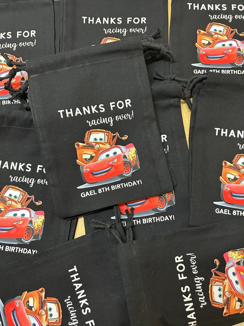 Puede incluir: Bolsas de cord&oacute;n negras con un tema de Cars. Las bolsas presentan a los personajes Rayo McQueen y Mate. El texto en las bolsas dice "&iexcl;Gracias por venir!" y "&iexcl;Gael 8&ordm; cumplea&ntilde;os!"