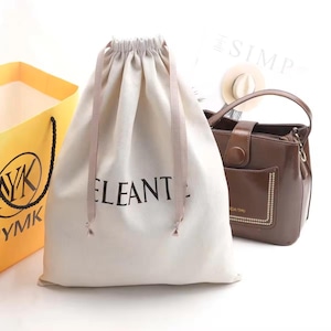 May include: A white drawstring bag with the word "Eleante" printed on it. The bag is made of cotton and has a natural, unbleached color. It is a great way to store and protect your belongings.