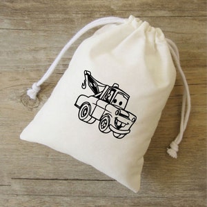 Puede incluir: Una bolsa de algod&oacute;n blanco con cord&oacute;n de ajuste, con una imagen de dibujos animados en blanco y negro de una gr&uacute;a de remolque sonriente.