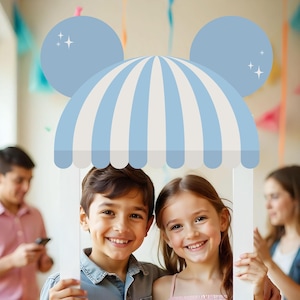 May include: A white photo booth frame with a blue and white striped awning and Mickey Mouse ears. The frame says "Skylar's 3rd Birthday". Two children are holding the frame and smiling.