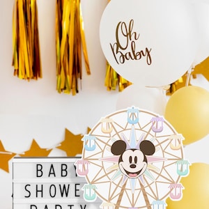 May include: A white balloon with gold lettering that says "Oh Baby" and a Mickey Mouse Ferris wheel centrepiece with pastel coloured gondolas. The background includes gold tassel streamers and a white letter board that says "Baby Shower Party".