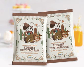 Op de afbeelding: Twee witte zakken met bruine bovenkanten met een cartoonafbeelding van Mickey Mouse verkleed als cowboy. De zakken hebben de tekst "Saddle up for a snack! Kenneth's First Rodeo Bash No outlaw leaves hungry! Yee haw!" erop gedrukt.