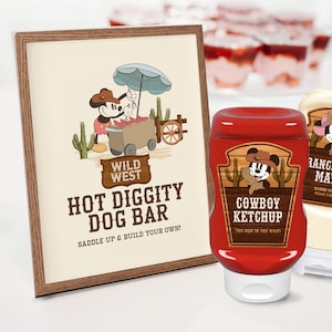 Puede incluir: Un cartel enmarcado de madera con una imagen de dibujos animados de Mickey Mouse vestido de vaquero, con el texto "Wild West Hot Diggity Dog Bar Saddle Up & Build Your Own!" Dos botellas de condimento, una roja con "Cowboy Ketchup" y una blanca con "Rancher's Mayo" están en primer plano.