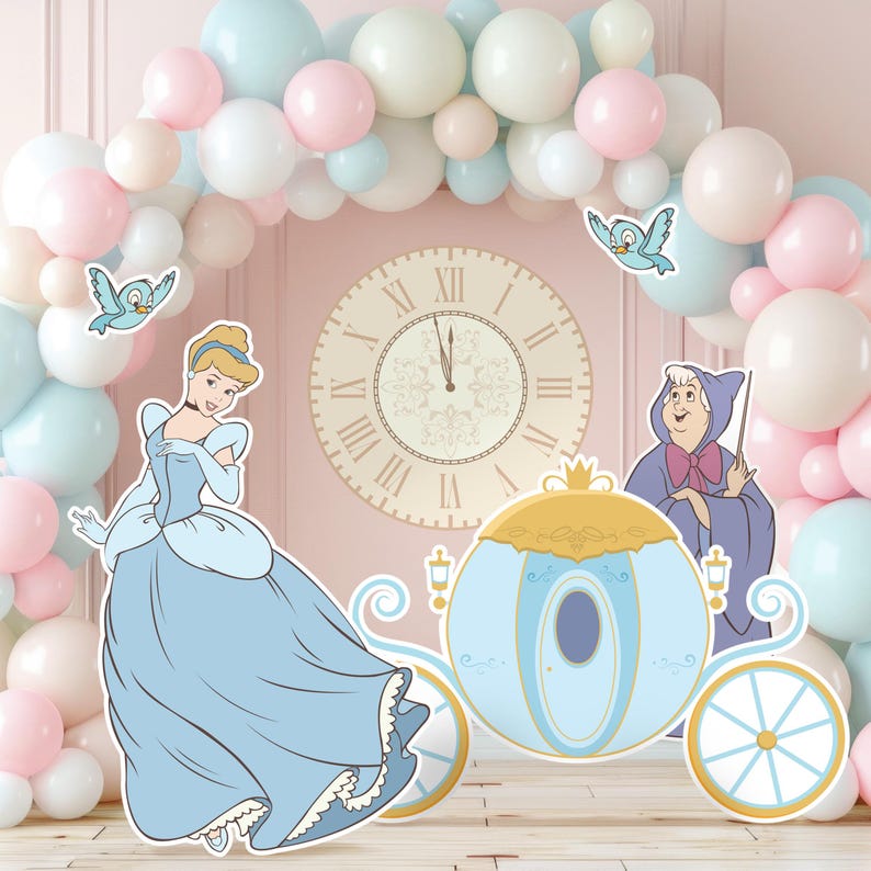 May include: A party decoration set featuring Cinderella, her carriage, and the Fairy Godmother. The scene is set against a backdrop of pastel balloons and a large clock. The characters are in light blue, gold, and white.