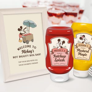 May include: A white framed sign with the text "Welcome to Mickey's Hot Diggity Dog Bar! Top your dog with all your favorite fixings!"  Two condiment bottles, one red with "Mickey's Favorite Ketchup Splash" and one yellow with "Minnie's Favorite Mustard Magic".