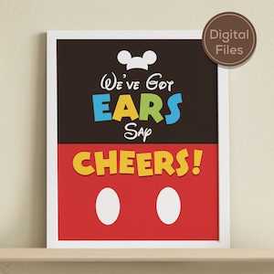 May include: A printable sign with a Mickey Mouse theme. The sign is black, red, and yellow with the text "We've got ears say cheers!" and two white circles.