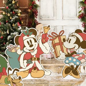 May include: Mickey Mouse dressed as Santa Claus with a red bag full of presents, Minnie Mouse holding a wrapped gift, and Pluto wearing a wreath around his neck. The characters are standing in front of a wooden door with a Christmas tree on each side.