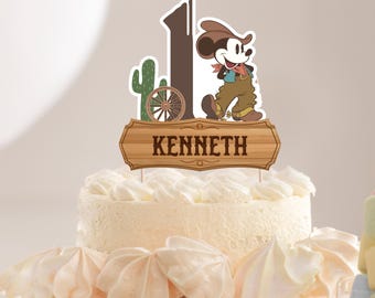 May include: A cake topper featuring a cartoon cowboy Mickey Mouse with a brown hat, brown trousers, and a blue bandana. The topper also includes a wooden sign with the name "KENNETH" and a cactus and wagon wheel.