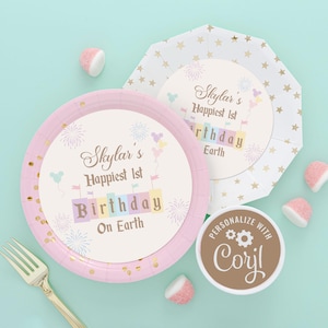May include: Pink and white paper plates with gold glitter and a personalized design that says "Skylar's Happiest 1st Birthday on Earth". The plates are decorated with fireworks, balloons, and a castle. The design also includes a small logo that says "Personalize with Coryl".