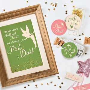 Puede incluir: Una impresión enmarcada con un fondo verde y purpurina dorada. La impresión presenta una silueta de Campanilla con el texto "Todo lo que necesitas es fe y confianza y un poco de polvo de hada". Hay tres pequeñas botellas de vidrio con tapones de corcho llenas de purpurina dorada y una etiqueta redonda rosa, verde y crema que dice "Polvo de Hada". También hay una varita de estrella rosa brillante con una cinta blanca que dice "Polvo de Hada".