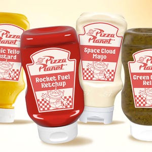 Puede incluir: Cuatro botellas de condimentos Pizza Planet: "Cosmic Yellow Mustard", "Rocket Fuel Ketchup", "Space Cloud Mayo" y "Green Galaxy Relish". Cada botella tiene una etiqueta blanca con el logo de Pizza Planet y un gráfico alienígena.