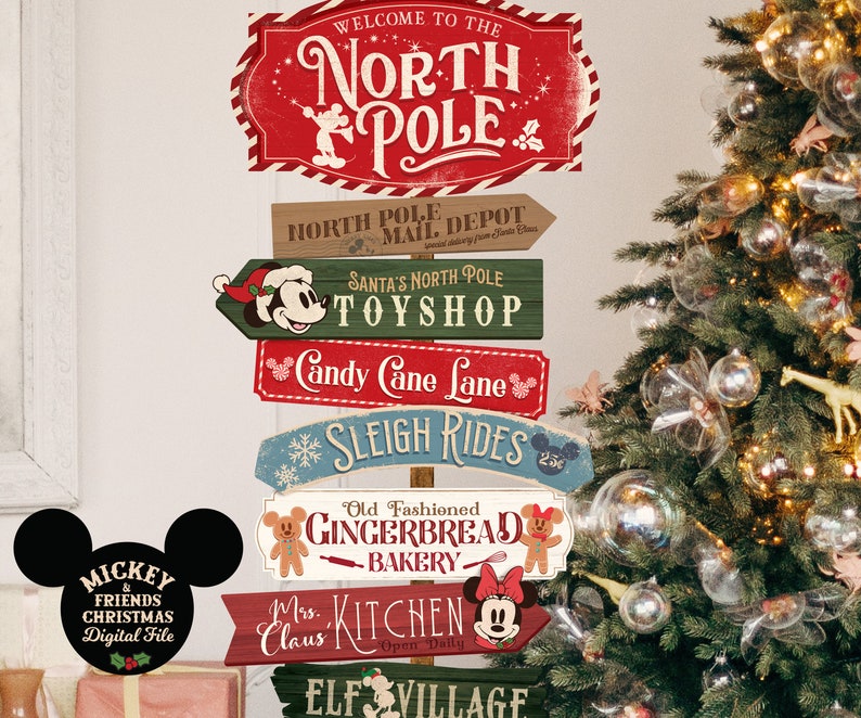 May include: A set of six wooden signs with a Christmas theme featuring Mickey Mouse and Minnie Mouse. The signs are decorated with red, green, and blue paint and have a vintage look. The signs are arranged in a stack and feature the text "Welcome to the North Pole", "North Pole Mail Depot", "Santa's North Pole Toyshop", "Candy Cane Lane", "Sleigh Rides", "Old Fashioned Gingerbread Bakery", "Mrs. Claus Kitchen", and "Elf Village".