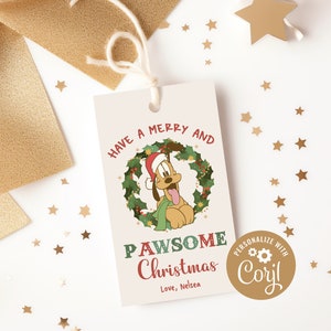 May include: A white gift tag with a cartoon dog wearing a Santa hat in a green holly wreath. The text reads "Have a Merry and PAWsome Christmas" and "Love, Nelsea". A gold circle with the text "Personalize with Cory!" is in the bottom right corner.