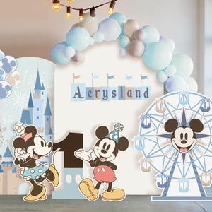 Op de afbeelding: Een feestachtergrondset met een grote witte boog met de tekst Aerysland, een blauw kasteelpaneel met ballonnen, een groot cijfer één, twee cartoonmuisfiguren en een reuzenrad-uitsparing, allemaal versierd met lichtblauwe en beige ballonnen.