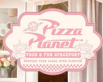 Può includere: Un'insegna rosa e crema di Pizza Planet con la scritta "Pizza Planet" e "Food & Fun Spaceport". L'insegna presenta alieni dei cartoni animati e una grafica del pianeta. L'insegna è appesa davanti a una finestra con palloncini rosa e bianchi.