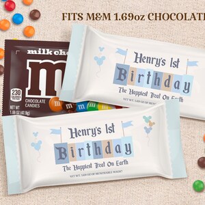Könnte beinhalten: Ein personalisierter M&M's-Schokoladenriegel-Wrapper in Blau und Weiß mit dem Text "Henry's 1st Birthday" und "The Happiest Treat On Earth".