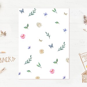 May include: A white background with a repeating pattern of watercolor flowers, leaves, and butterflies. The flowers are pink, white, and light blue. The butterflies are blue. The leaves are green.