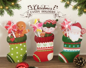Op de afbeelding: Drie kerstsokken-snoepjeshouders met verschillende personages. De eerste sok heeft een peperkoekman, de tweede een elf en de derde Sinterklaas. Elke sok bevat een snoepstok.