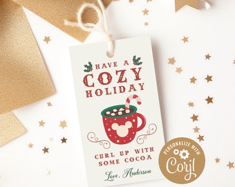 May include: A white gift tag with red and green text that reads "Have a Cozy Holiday". The tag features a red mug with a white Mickey Mouse head and a candy cane sticking out of the top. The text "Curl up with some cocoa" is below the mug. The tag is personalized with the text "Love, Anderson" and a gold circle with the text "Personalize with Corjl".