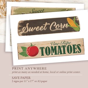 May include: Three printable signs with a rustic woodgrain background. The signs feature the text "Sweet Corn" with an illustration of an ear of corn, "Vine-Ripe Tomatoes" with an illustration of a tomato, and "Sweet" with a green background.