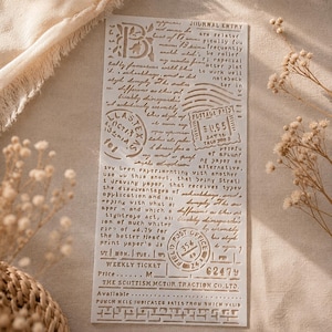 Könnte beinhalten: Eine Schablone mit Vintage-Design in Beige. Sie zeigt Text, Stempel und einen großen Buchstaben "B". Die Schablone hat ein abgenutztes, gealtertes Aussehen. Der Text enthält Sätze wie "Journal Entry" und "Weekly Ticket".