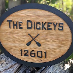 May include: Oval wooden sign with a black border. The sign says "THE DICKEYS" with a pair of crossed oars underneath and the number "12601" below the oars.